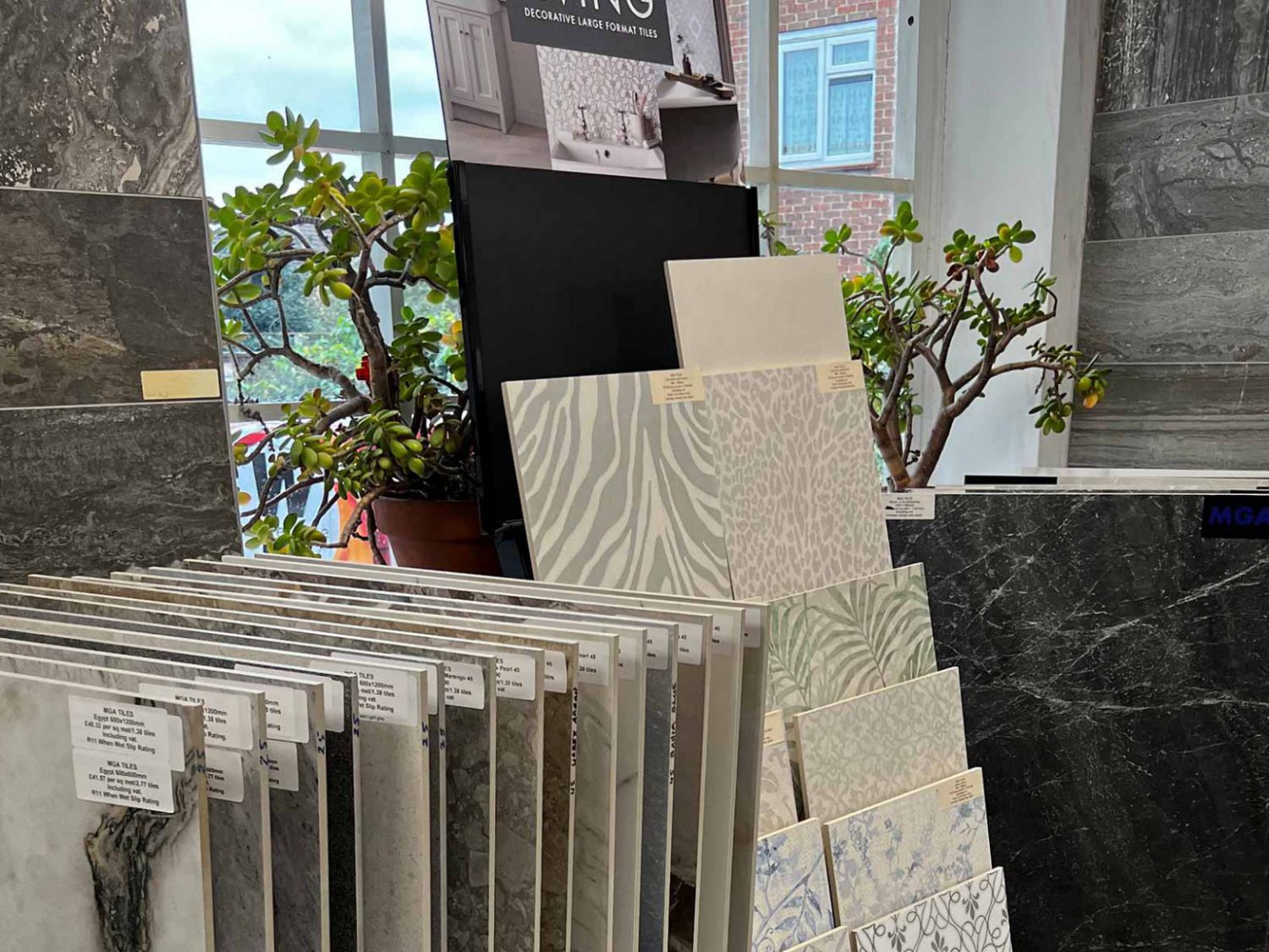 Different types of tiles displayed next to a window and two plant pots
