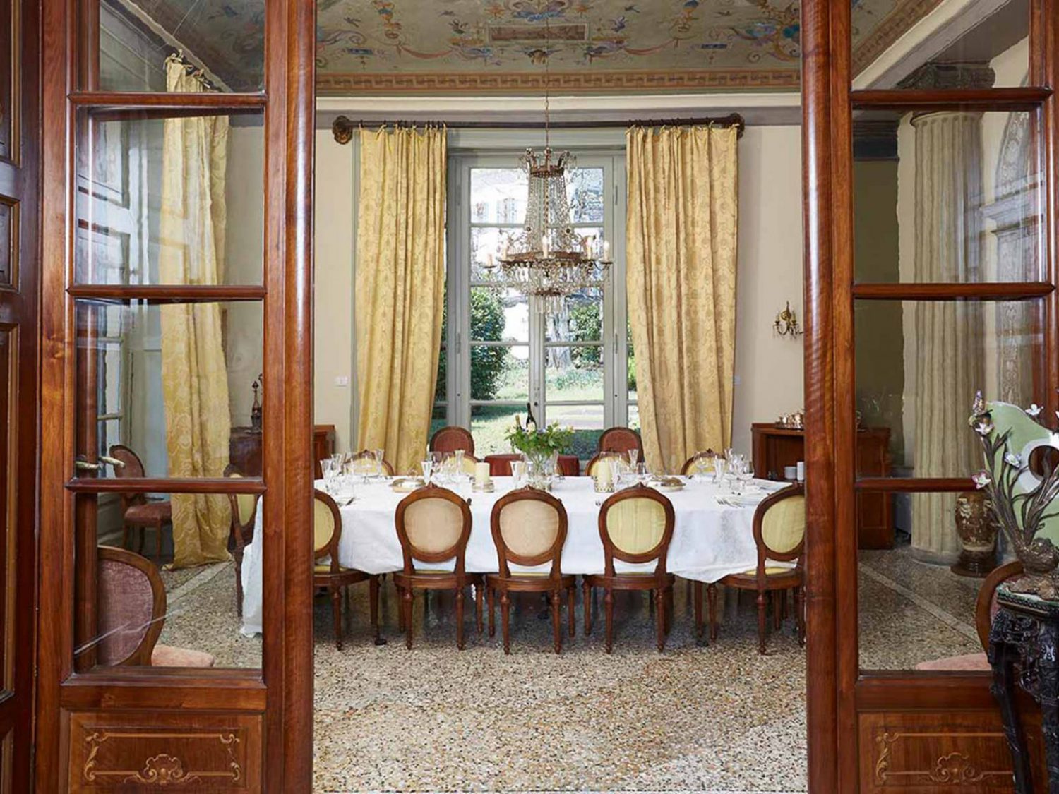 Living room with wood chairs, chandelier and yellow curtains